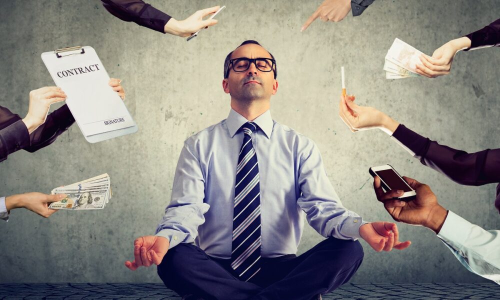 Mature business man is meditating to relieve stress of busy corporate life